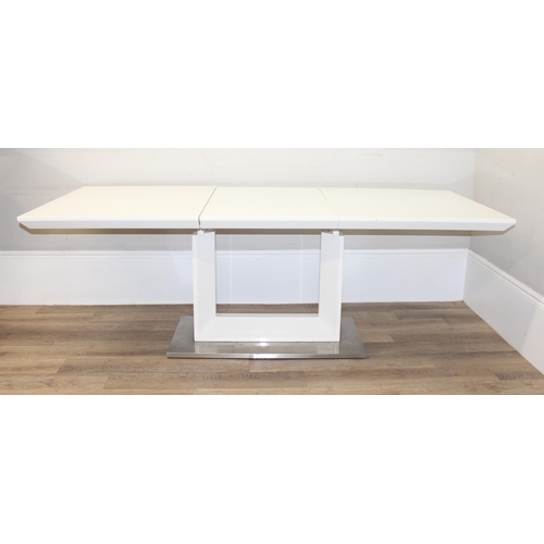 134 - A large modern white extending dining table with brushed steel base, seemingly unmarked, approx 160c... 