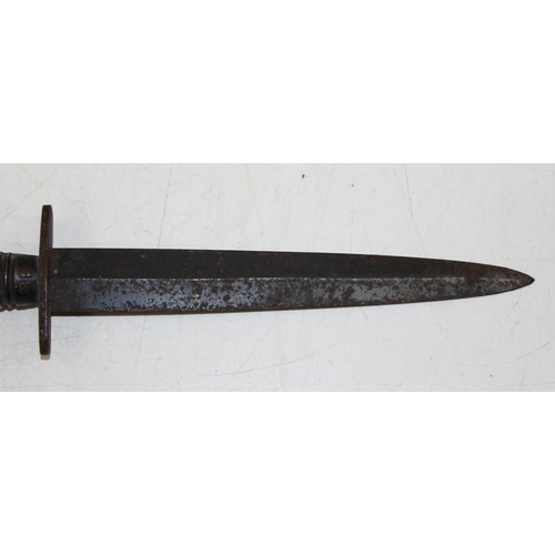 1375 - A Fairbairn-Sykes style commando fighting knife with ribbed handle, the only visible marks a crossed... 