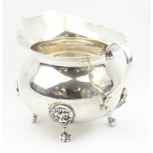 1009D - A vintage silver cream jug with frilled edges, lion mask and paw handles, marked Sterling and XRF co... 