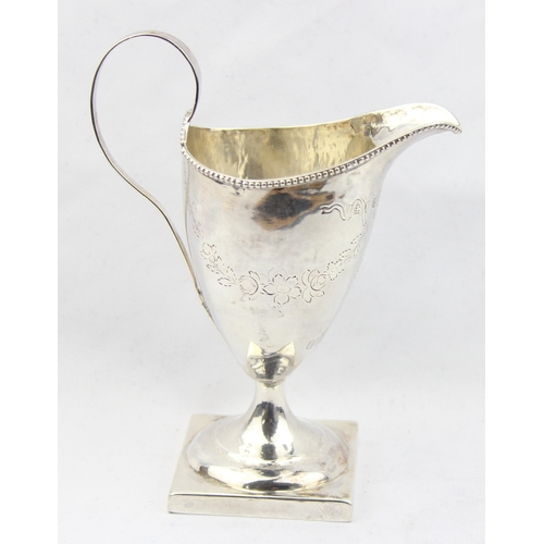 1081 - A Georgian silver helmet shaped cream jug with engraved decoration, marked for London 1787 with a ru... 