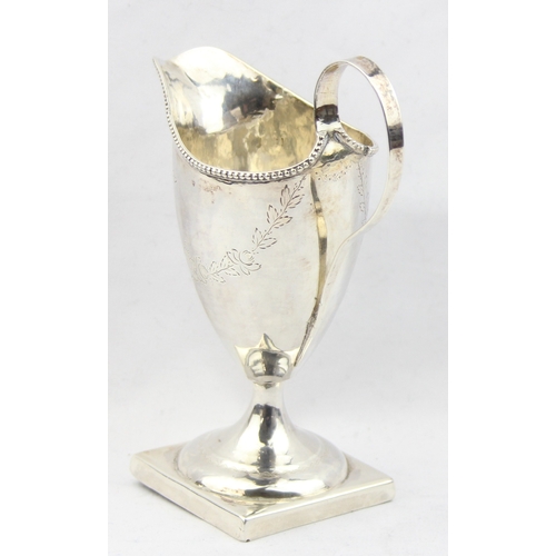 1081 - A Georgian silver helmet shaped cream jug with engraved decoration, marked for London 1787 with a ru... 