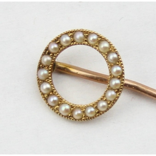 1101 - A 19th century 15ct gold stick pin set with seed pearls in a circular setting, the pin 9ct gold, unm... 