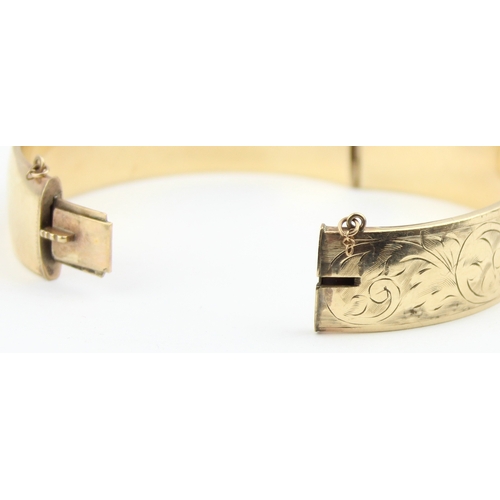 1117 - A vintage bangle with engraved decoration, marked 1/5th 9ct gold with metal core, approx 70mm wide, ... 