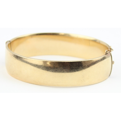 1117 - A vintage bangle with engraved decoration, marked 1/5th 9ct gold with metal core, approx 70mm wide, ... 