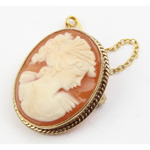 1129 - A 9ct gold mounted shell cameo brooch carved with the head of a classical female, marked and XRF con... 