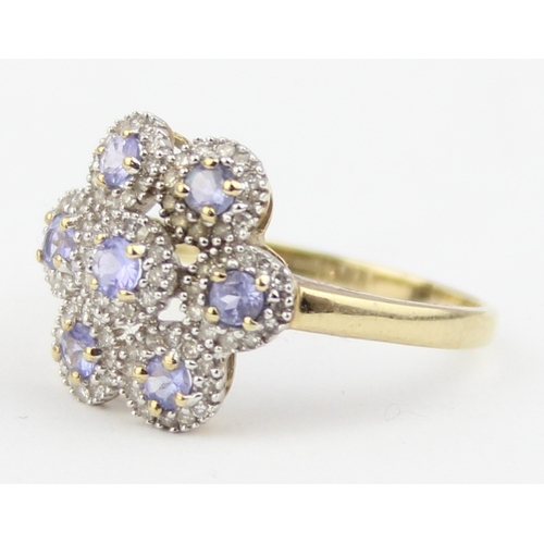 1130 - A 9ct gold floral cluster ring, 7 central lilac coloured stones surrounded by small white stones, ma... 