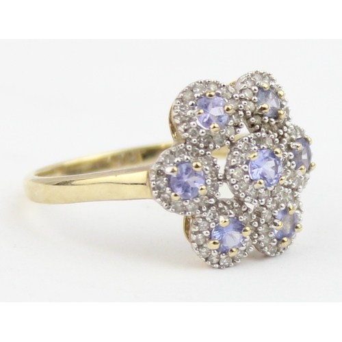 1130 - A 9ct gold floral cluster ring, 7 central lilac coloured stones surrounded by small white stones, ma... 