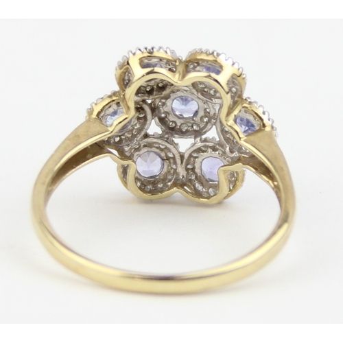 1130 - A 9ct gold floral cluster ring, 7 central lilac coloured stones surrounded by small white stones, ma... 