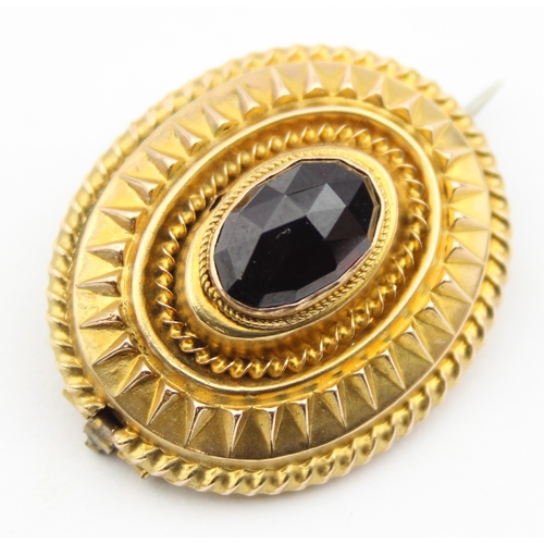 1137 - A Victorian 15ct gold brooch set with a facet cut red stone, possibly a Garnet, seemingly unmarked b... 