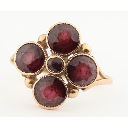 1141 - A Georgian style 9ct gold ring set with pink stones in a floral setting, believed to be Garnets, ind... 