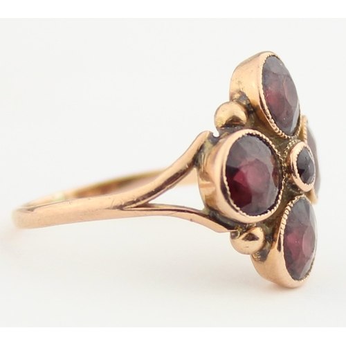 1141 - A Georgian style 9ct gold ring set with pink stones in a floral setting, believed to be Garnets, ind... 