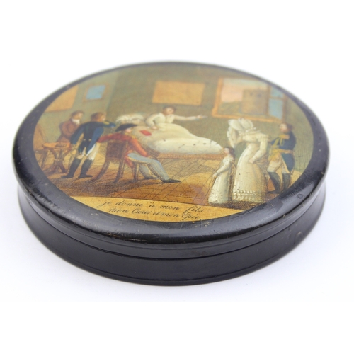 1451 - An early 19th century lacquered papier mache circular snuff box printed with a crowded tavern scene,... 