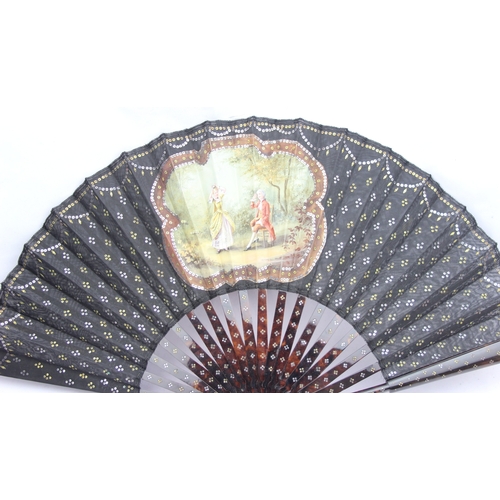 1452 - An antique tortoiseshell, black lace and painted silk fan, the vignette painted with a scene of a co... 