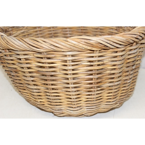 289 - A large vintage wicker basket with 2 handles and rounded base, approx 54cm wide