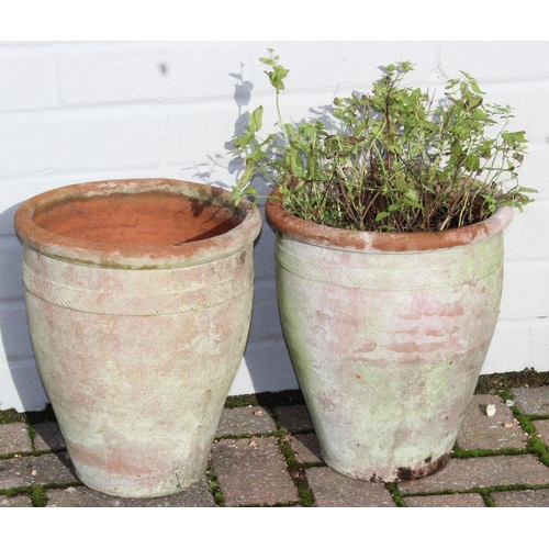 310 - A pair of weathered urn shaped terracotta garden planters, each approx 28cm in diameter x 31cm tall