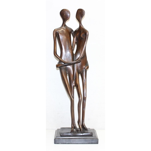 374B - A heavy bronzed metal sculpture of an embraced naked couple, seemingly unsigned, on marble base, mad... 