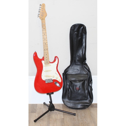 752 - A vintage electric guitar in the shape of a Fender Stratocaster, red wooden body, seemingly unmarked... 