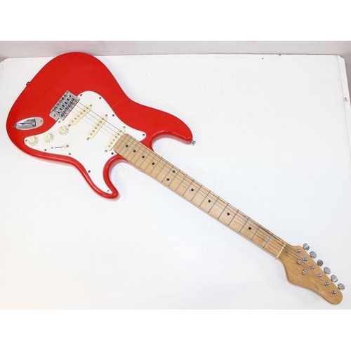 752 - A vintage electric guitar in the shape of a Fender Stratocaster, red wooden body, seemingly unmarked... 