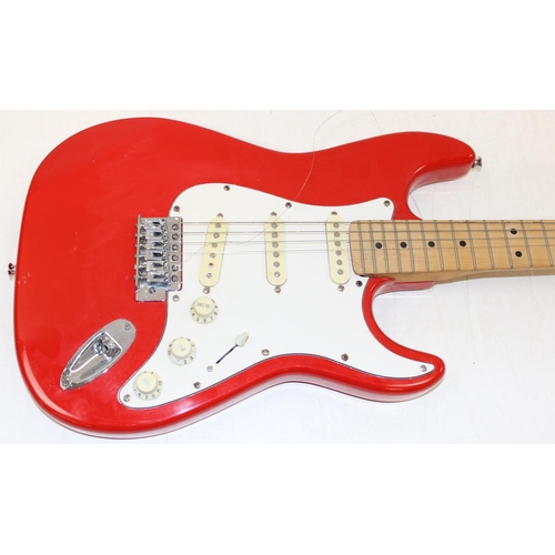 752 - A vintage electric guitar in the shape of a Fender Stratocaster, red wooden body, seemingly unmarked... 