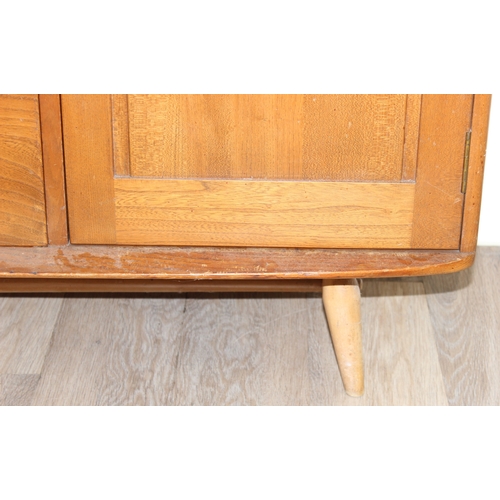 22 - A retro Ercol 3 door single drawer sideboard, believed to be a model 467, on splayed legs, approx 11... 