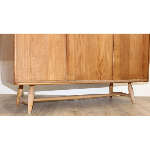 22 - A retro Ercol 3 door single drawer sideboard, believed to be a model 467, on splayed legs, approx 11... 