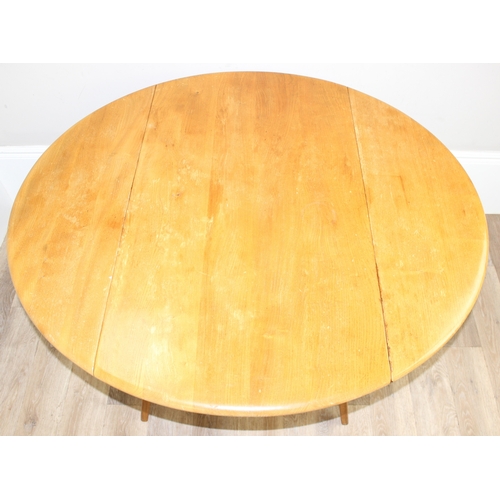 28 - A retro Ercol circular or oval topped drop leaf dining table, approx 65cm wide (124 cm extended) x 1... 