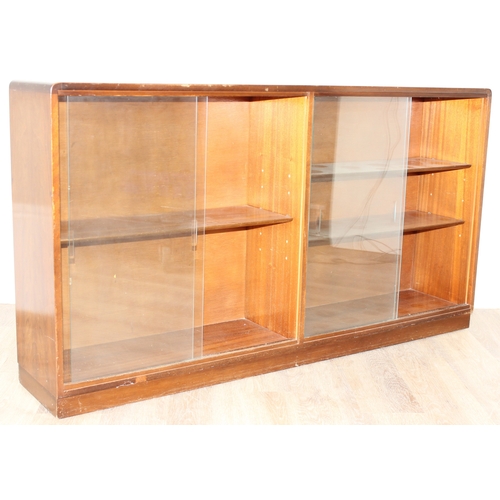 37 - A mid-century retro glazed 2 door bookcase, seemingly unmarked, approx 136cm wide x 27cm deep x 75cm... 