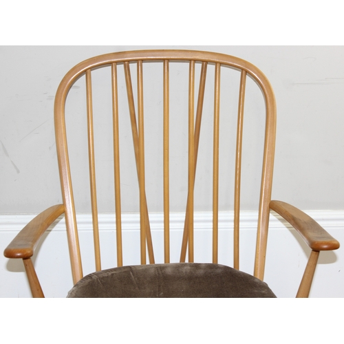 35 - A retro Ercol armchair believed to be a model 203 with sage green colour cushions, black and gold la... 