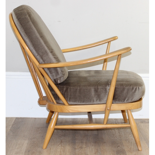 33 - A retro Ercol armchair believed to be a model 203 with sage green colour cushions, black and gold la... 