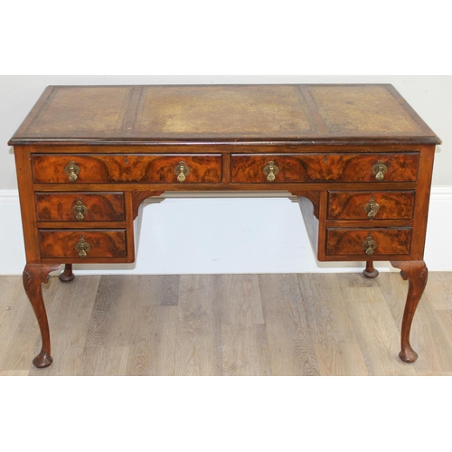 109 - An early 20th century walnut desk with cabriole legs and distressed leather top, the desk drawers wi... 