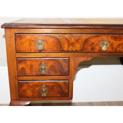 109 - An early 20th century walnut desk with cabriole legs and distressed leather top, the desk drawers wi... 