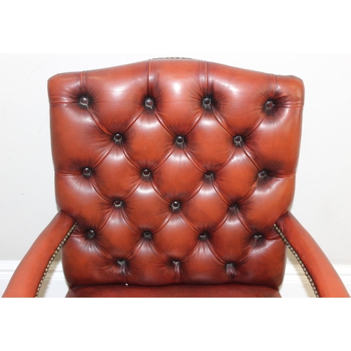 188 - A Chesterfield style dark tan-brown leather button-back armchair with exposed wooden frame, approx 9... 