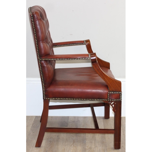 188 - A Chesterfield style dark tan-brown leather button-back armchair with exposed wooden frame, approx 9... 