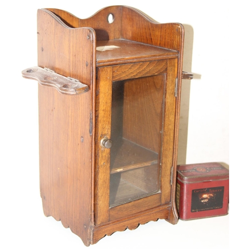 275 - An early 20th century oak pipe or smokers cabinet with glazed door and a vintage Carlysle Tobacco ti... 