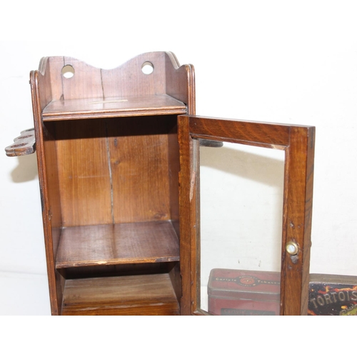 275 - An early 20th century oak pipe or smokers cabinet with glazed door and a vintage Carlysle Tobacco ti... 