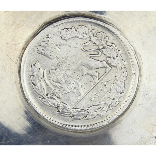 1099F - [55.87g] - an unmarked low grade silver dish set with an Iranian 5000 dinars silver coin, the dish X... 