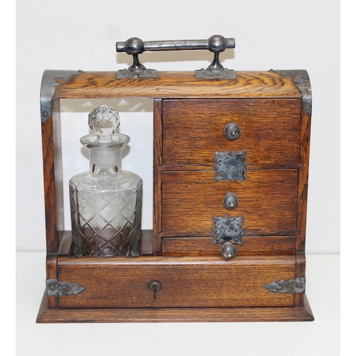 299A - A vintage oak tantalus of unusual form with single bottle and 3 drawers, the decanter a replacement,... 