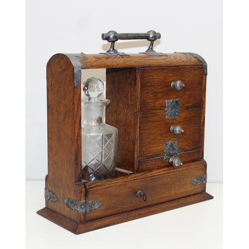 299A - A vintage oak tantalus of unusual form with single bottle and 3 drawers, the decanter a replacement,... 