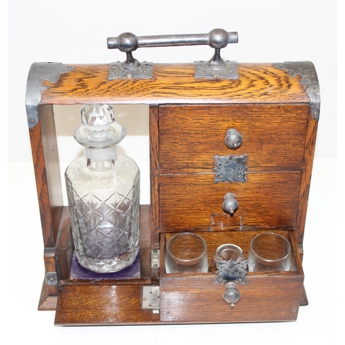 299A - A vintage oak tantalus of unusual form with single bottle and 3 drawers, the decanter a replacement,... 