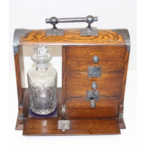 299A - A vintage oak tantalus of unusual form with single bottle and 3 drawers, the decanter a replacement,... 