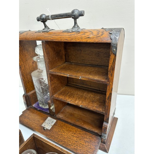 299A - A vintage oak tantalus of unusual form with single bottle and 3 drawers, the decanter a replacement,... 