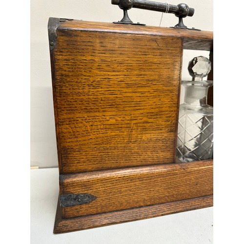 299A - A vintage oak tantalus of unusual form with single bottle and 3 drawers, the decanter a replacement,... 