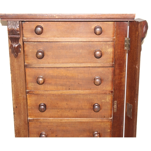 4 - An antique mahogany Wellington chest, seven drawers with turned handles and carved details to pillar... 