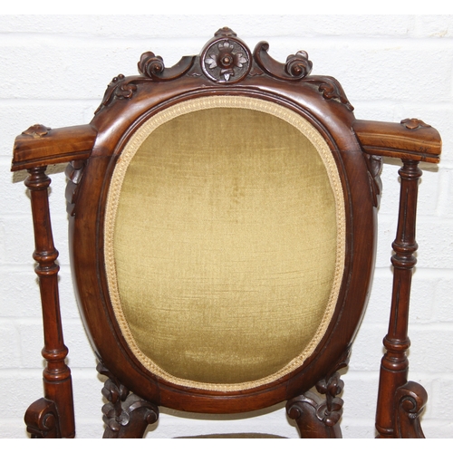 85 - A pair of decorative shield back armchairs with exposed carved frames and ceramic castors, 19th cent... 