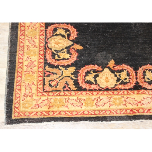 200 - A vintage Afghan rug of black ground with decorative gold border, label verso marked Zigler, 192cm x... 