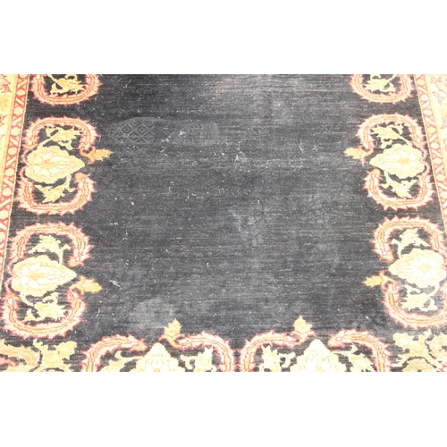 200 - A vintage Afghan rug of black ground with decorative gold border, label verso marked Zigler, 192cm x... 