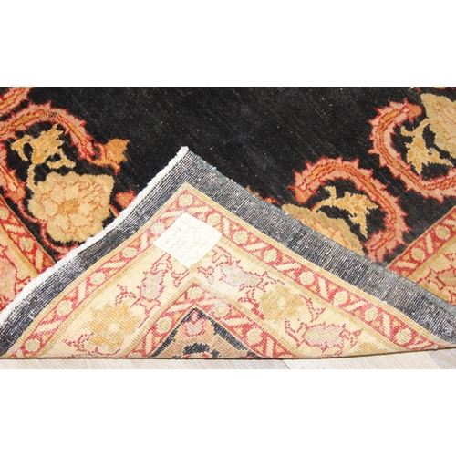 200 - A vintage Afghan rug of black ground with decorative gold border, label verso marked Zigler, 192cm x... 