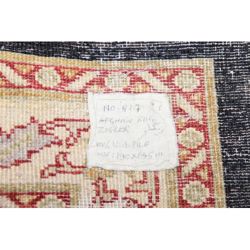 200 - A vintage Afghan rug of black ground with decorative gold border, label verso marked Zigler, 192cm x... 