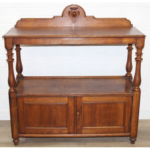 75 - An antique oak two tier buffet stand with cupboard base and carved frieze to top, late 19th or early... 