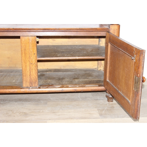 75 - An antique oak two tier buffet stand with cupboard base and carved frieze to top, late 19th or early... 